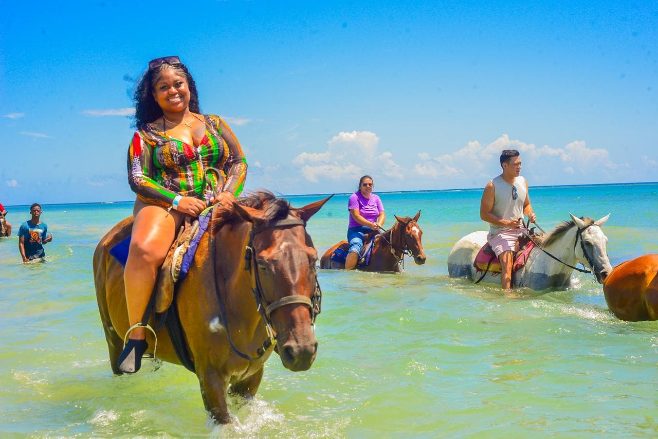 Guests riding horses in the sea on a MG Adventure Tours outing